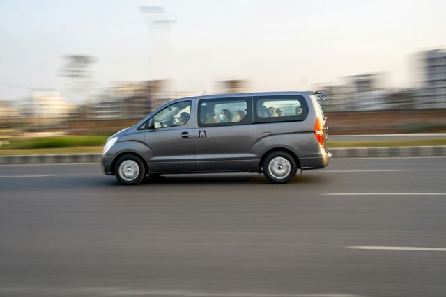 Een grijze personenbus onderweg